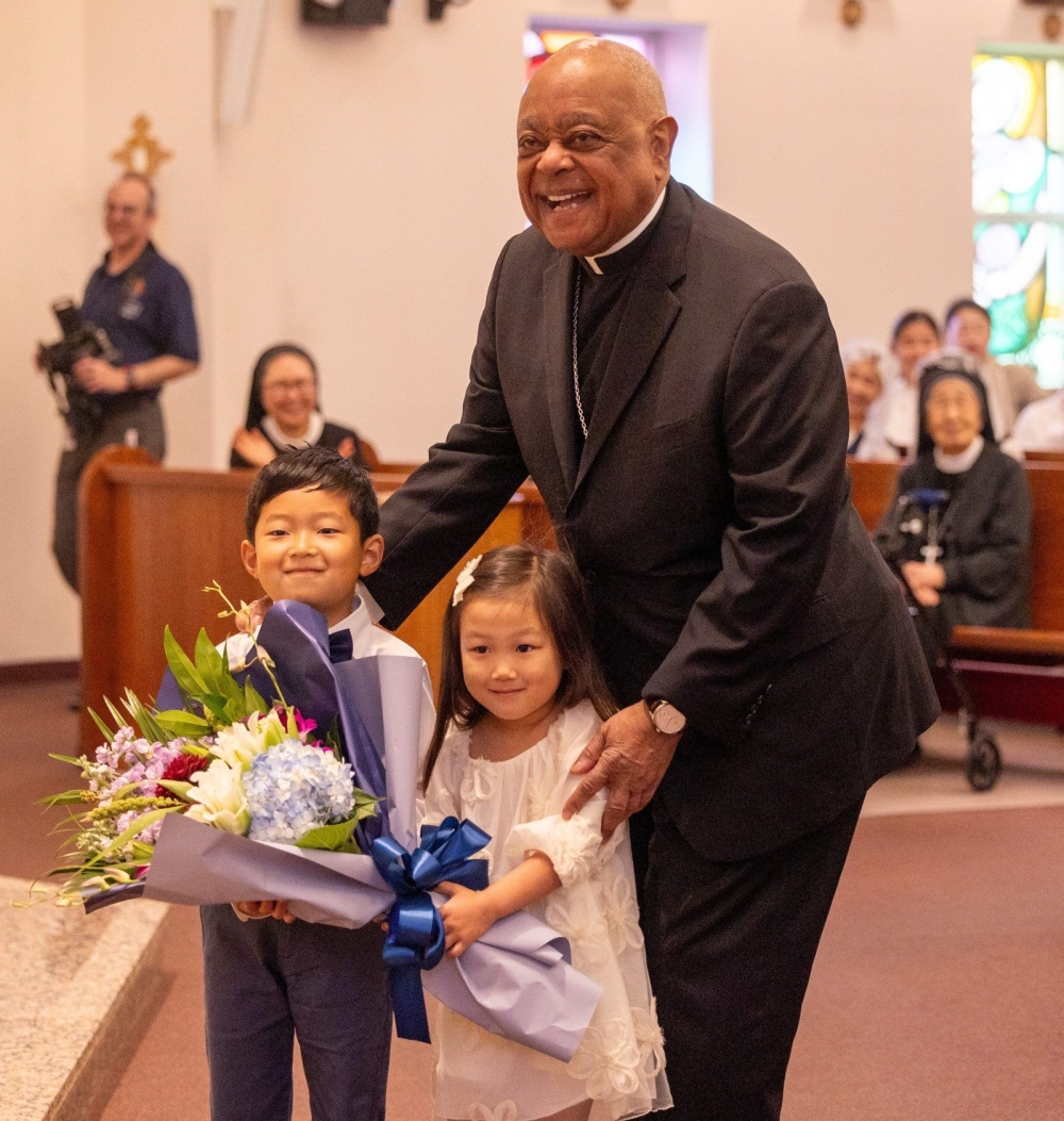 A young boy and a girl presented flowers to Washington Cardinal Wilton Gregory before he celebrated a Mass on Sept. 29, 2024 marking the 50th anniversary of St. Andrew Kim Parish in Olney, Maryland, that serves Korean Catholics. (Catholic Standard photos by Mihoko Owada)